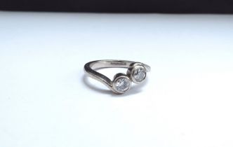 An 18ct white gold two diamond crossover ring. Size N, 5.3g