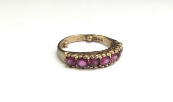 A 9ct gold seven stone ruby ring. Size K with spacers, 2.8g