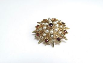 A 9ct gold seed pearl and garnet set star brooch, 6.8g
