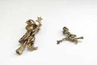 Two 9ct gold pendants as witches on broomsticks, one stone set with articulated parts, 9.7g