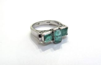 A white gold ring set with three emerald cut emeralds the central vertical stone 0.60ct flanked by