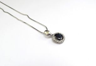 A white gold sapphire and diamond cluster pendant stamped 18k hung on an 18ct white gold chain, 40cm
