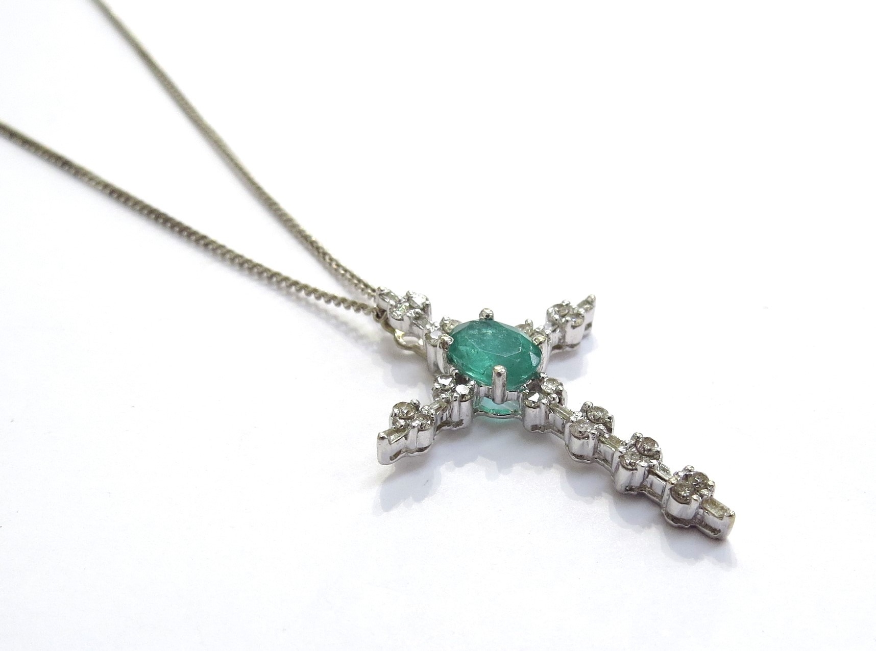An emerald and diamond set cross pendant the oval emerald 0.75ct, 0.35ct diamond total, 18ct white