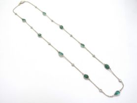 An emerald and diamond necklace with equally spaced stones on trace link chain, four oval emeralds