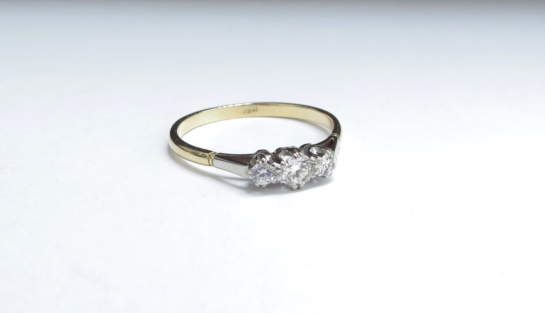 A three stone diamond ring, stamped 18ct. Size W/X, 2.6g