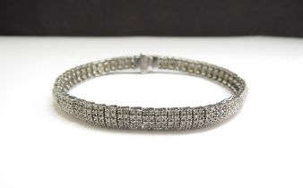 A 9ct white gold diamond bracelet, each articulated link with two rows of five diamonds, one diamond
