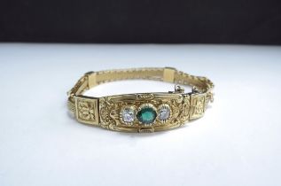 A French gold bracelet Circa 1900, with woven and box link strap, ornate scroll and leaf curved