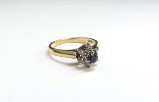 A sapphire and diamond chip flower ring, stamped 18ct. Size M, 3g