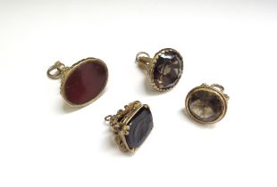 Four 9ct gold mounted seal fobs including smoky quartz, cornelian and onyx depicting a bust of a