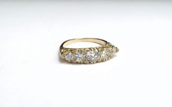 A graduated five stone diamond ring with a further ten old cut diamonds to outer in an ornate scroll