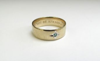 A 9ct gold band set with a single small emerald in star setting, engraved to inside band "DO NOT