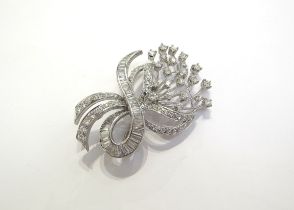 A diamond encrusted brooch as a floral spray of round brilliant cut diamonds with a baguette cut