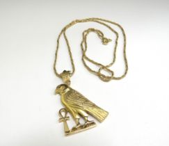 A gold Egyptian Horus Falcon and Ankh Pendant, 4cm long hung on a gold chain stamped 750, 60cm long,