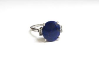 A white metal ring with circular lapis lazuli flanked by two diamonds, unmarked. Size M/N, 2.7g