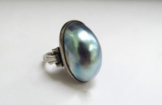 A white metal ring with a large domed oval mother-of-pearl. Size P, 7.4g