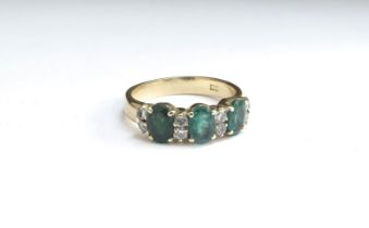 An 18ct gold diamond and emerald half eternity ring. Size O, 4.4g