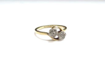 An 18ct gold ring with two floral diamond set clusters. Size L, 2.7g