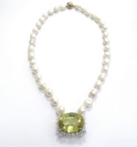 A single row of baroque shaped freshwater pearls with a large yellow quartz and diamond pendant,
