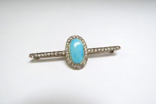 A large bar brooch with central oval framed and flanked by white topaz, unmarked, 7cm long, 7.5g