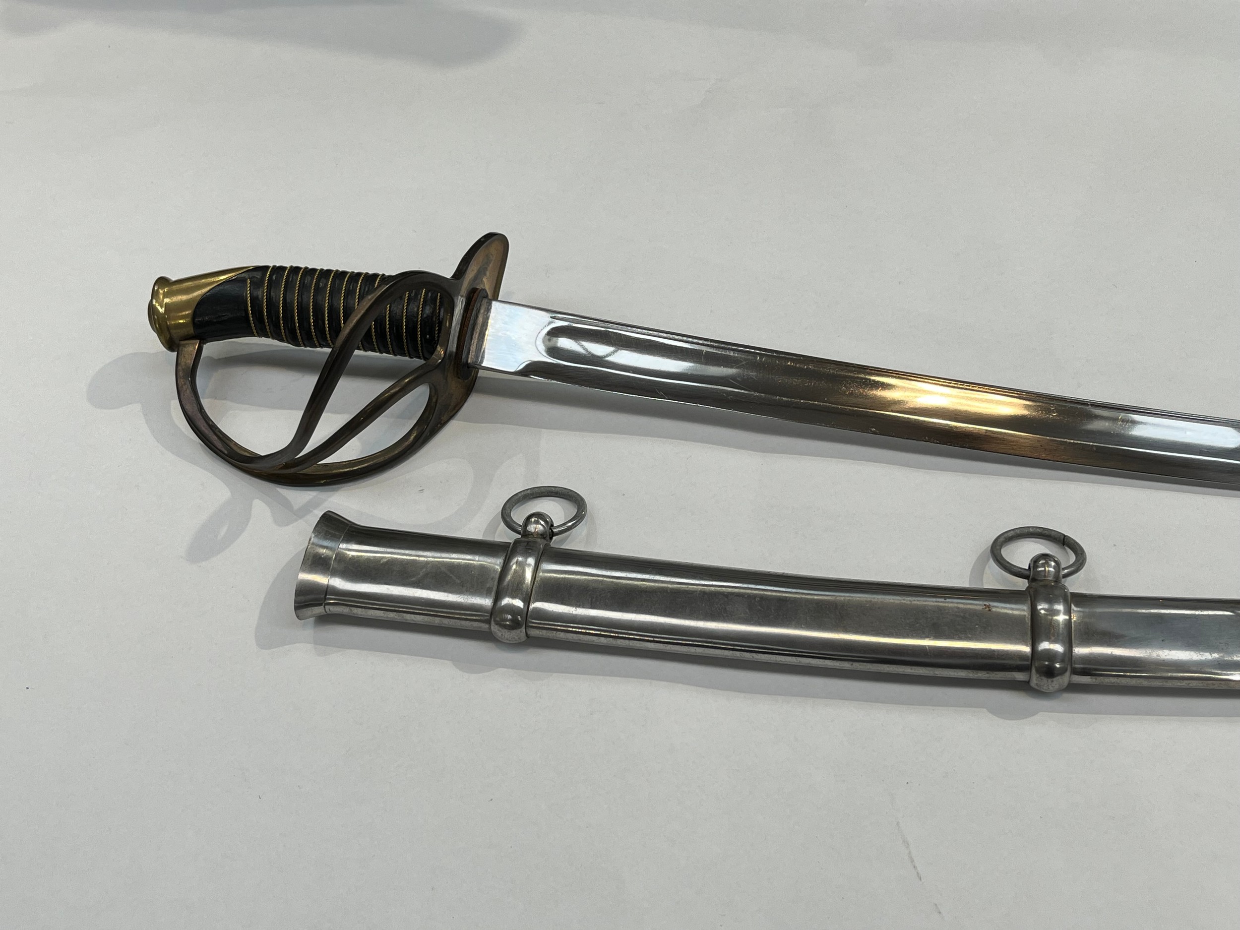 A replica cavalry officer’s sword, brass three bar hilt, wired grip, steel two-ring scabbard. For