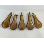 Five brass and copper powder flasks, four with embossed patterns including dogs and man leaning into