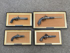 Four framed models of flintlock and percussion pistols, together with another of suit of armour, all