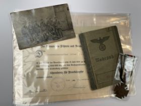 A WWI and WWII German group of documents with Cross of Honour and award document to Alfred