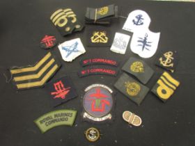 A collection of military insignia cloth badges including RN Commando Combined Operations and No. 7