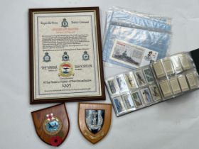 Two post war military shields together with an album containing photographs of HMS Rodney's visit to