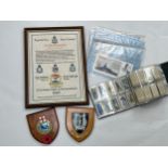 Two post war military shields together with an album containing photographs of HMS Rodney's visit to