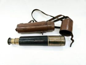 A vintage leather and brass telescope with brown leather case, no visible maker