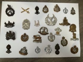 A display of British military badges including Norfolk Regiment, Gloucestershire and Suffolk