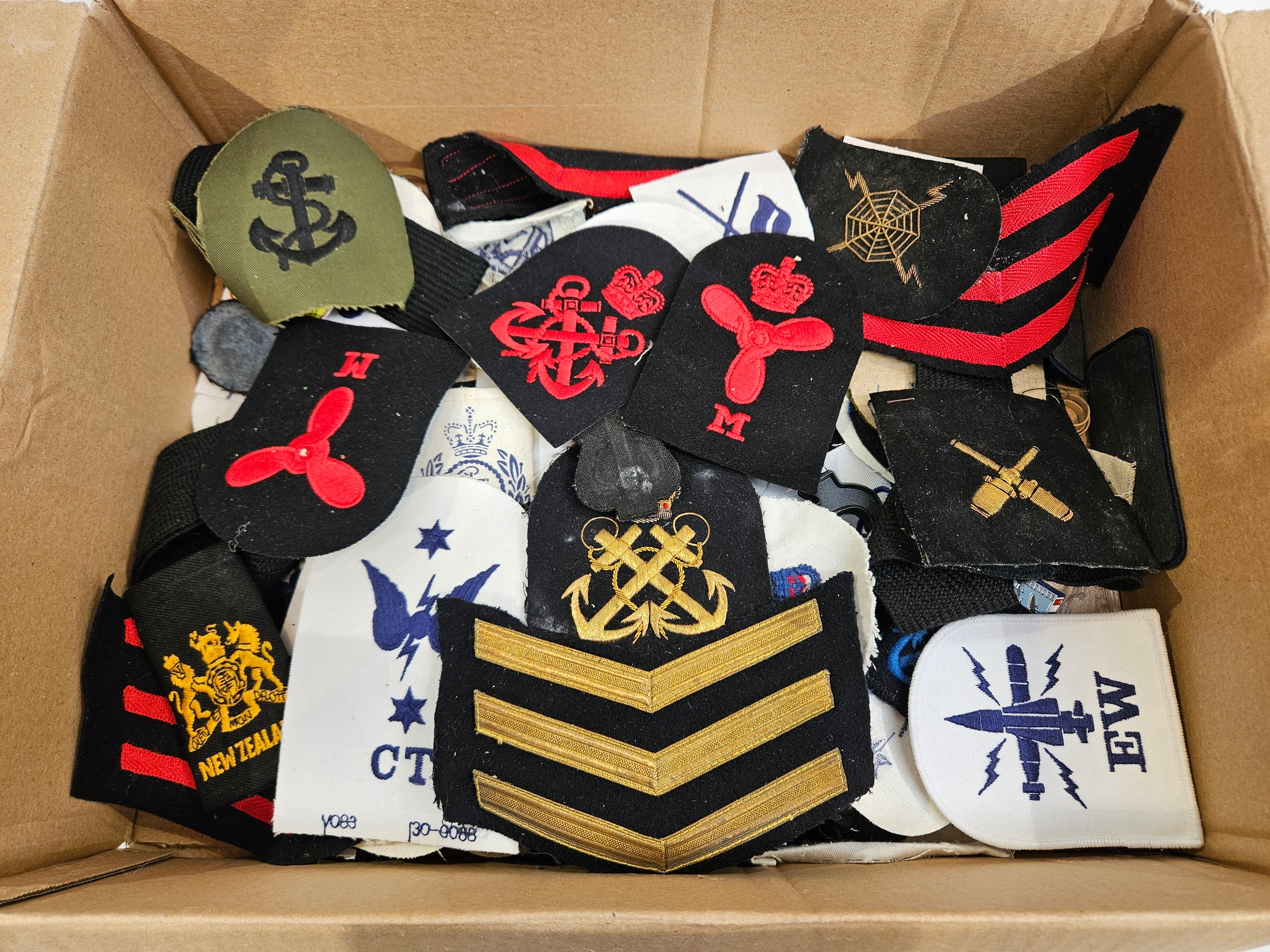 A box of mixed Royal Navy insignia