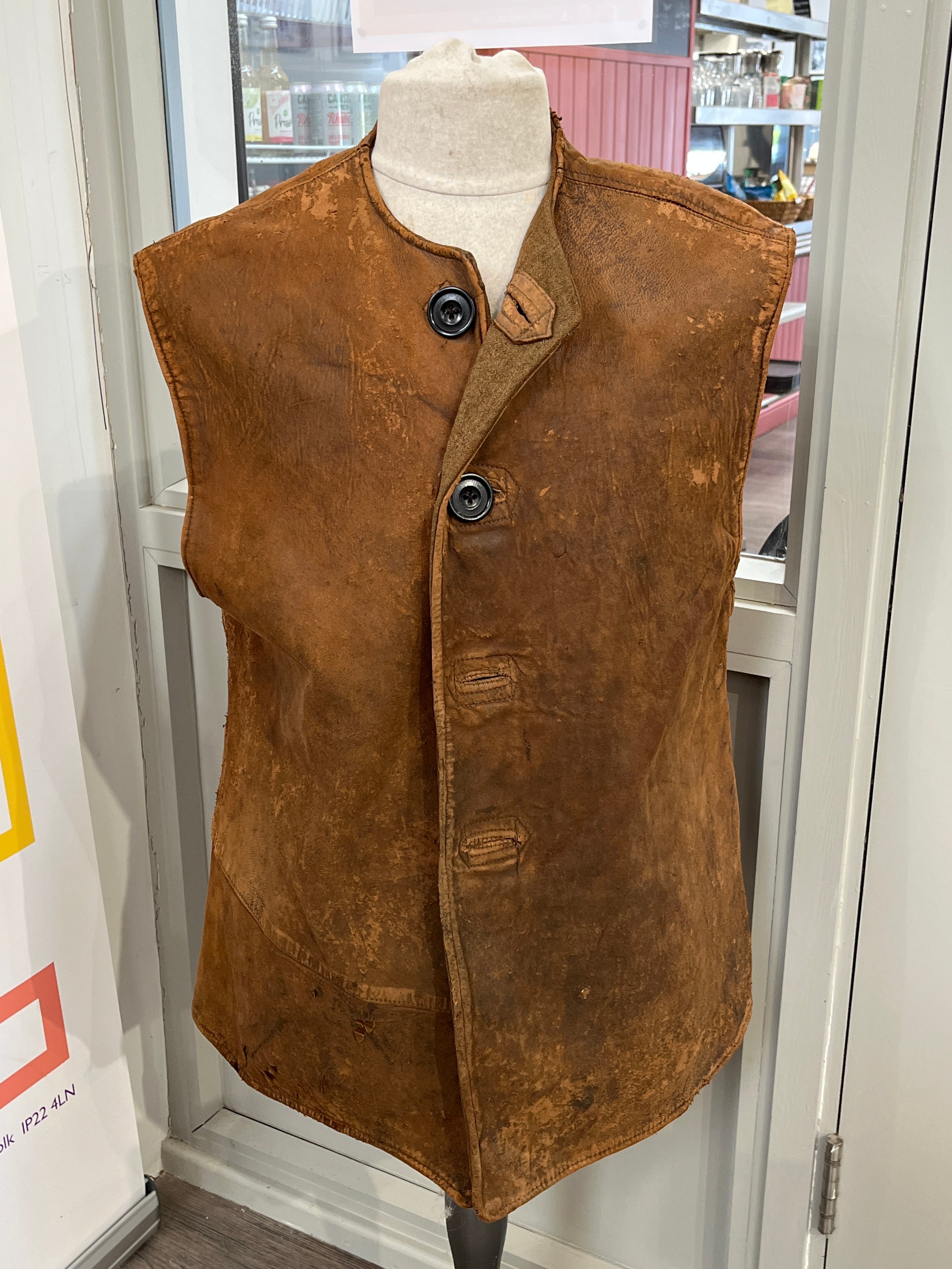 A WWII British leather jerkin, wool-lined, worn, original maker's label indistinct