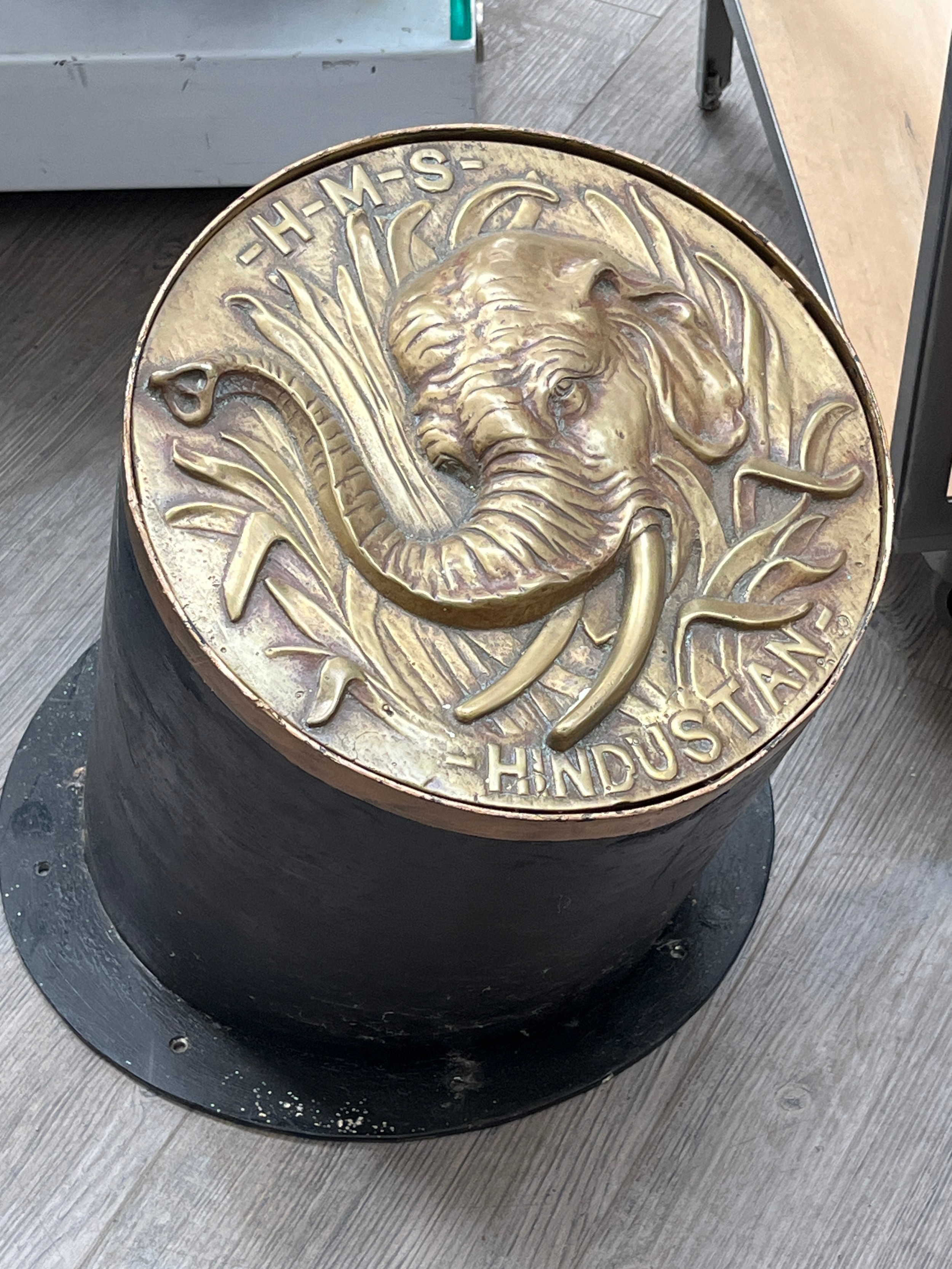An HMS HINDUSTAN gun tompion/tampion, cast brass with design of elephant, upon a cylindrical base