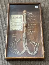 A framed display of a 'Cat O’ Nine Tails'