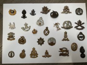 A display of British military badges including East Lancashire and Suffolk Regiment