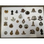 A display of British military badges including East Lancashire and Suffolk Regiment