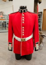 A half mannequin dressed in Irish Guards uniform together with boots and a great coat