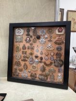A framed display of badges and buttons including RAF, Communist Russian and ARP