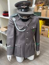 An East German Border Guard officer's jacket together with two East German visor caps with pale blue