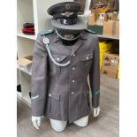 An East German Border Guard officer's jacket together with two East German visor caps with pale blue