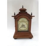 A German walnut cased architectural form striking mantel clock with Junghans movement, with