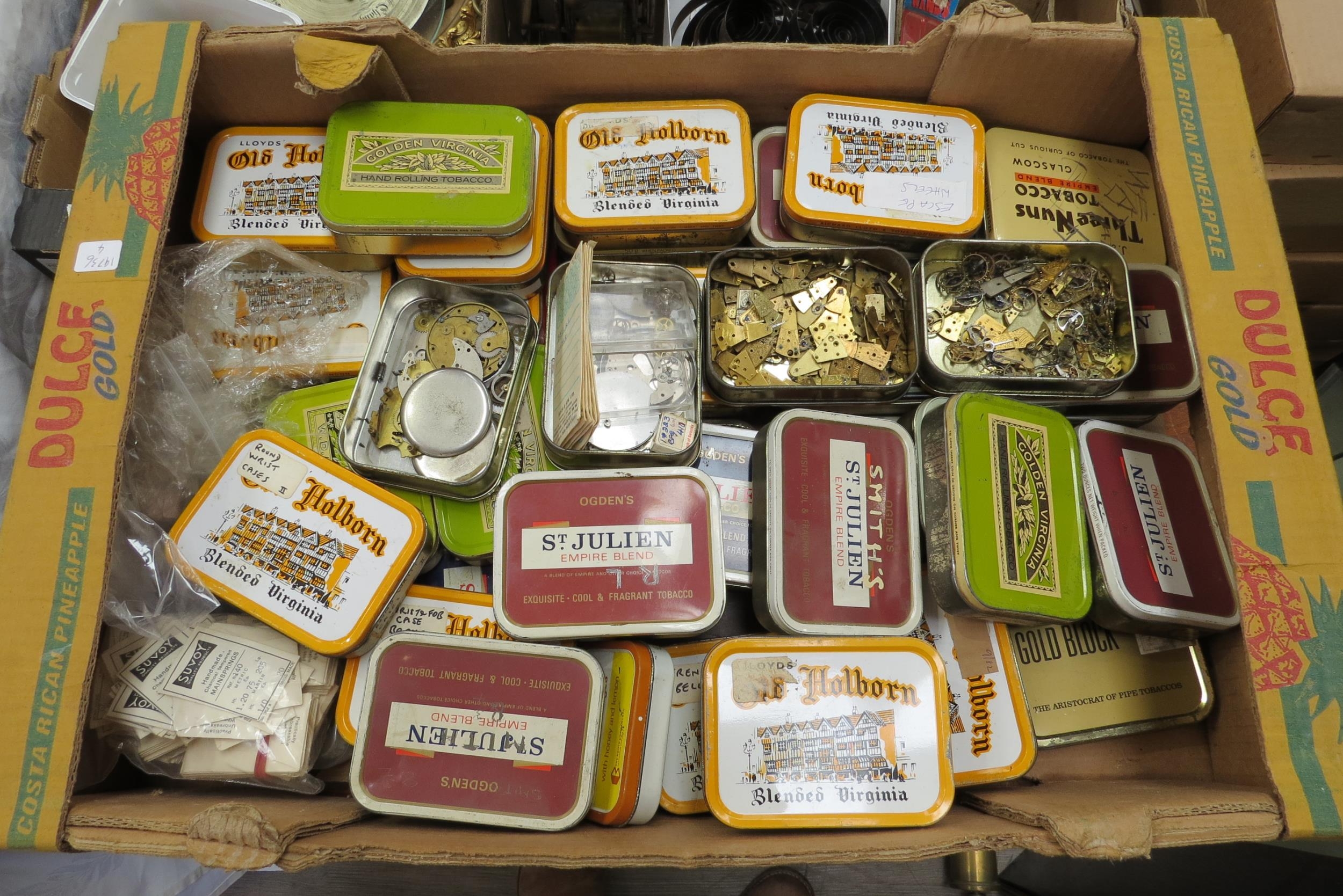 A large quantity of tobacco tins containing mixed watch spares, mainly balances, stems, dials,