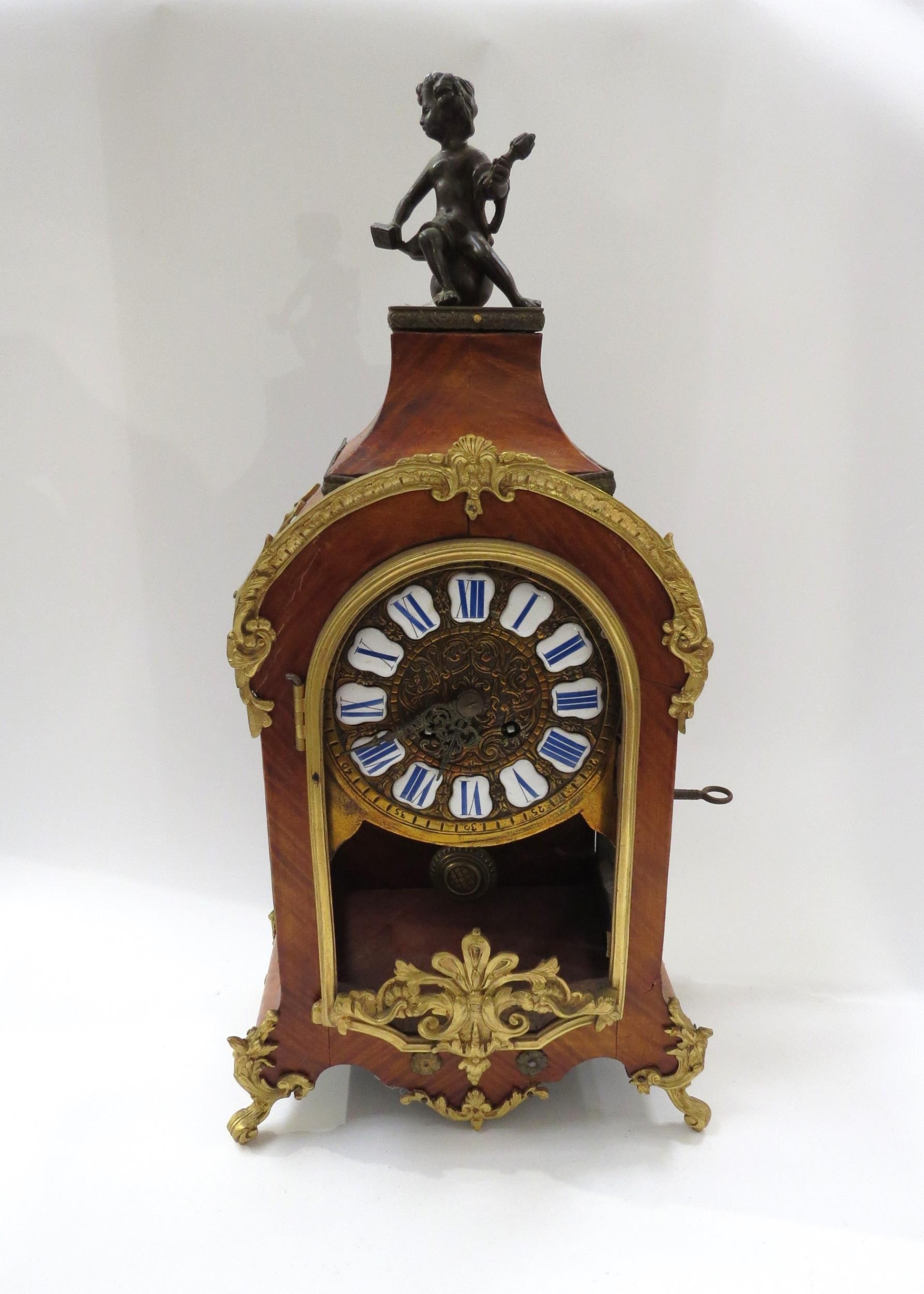 A late 19th Century French walnut and ormolu mounted striking mantel clock with ROman enamel