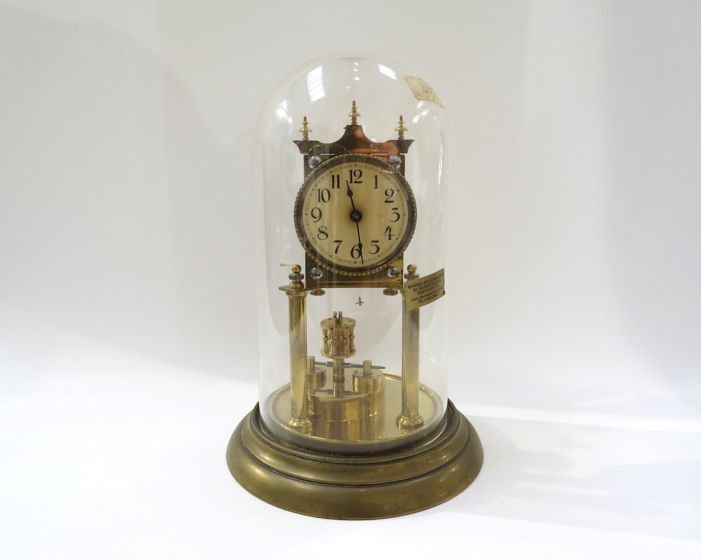 A Gustav Becker brass anniversary clock under plastic dome. 30cm tall
