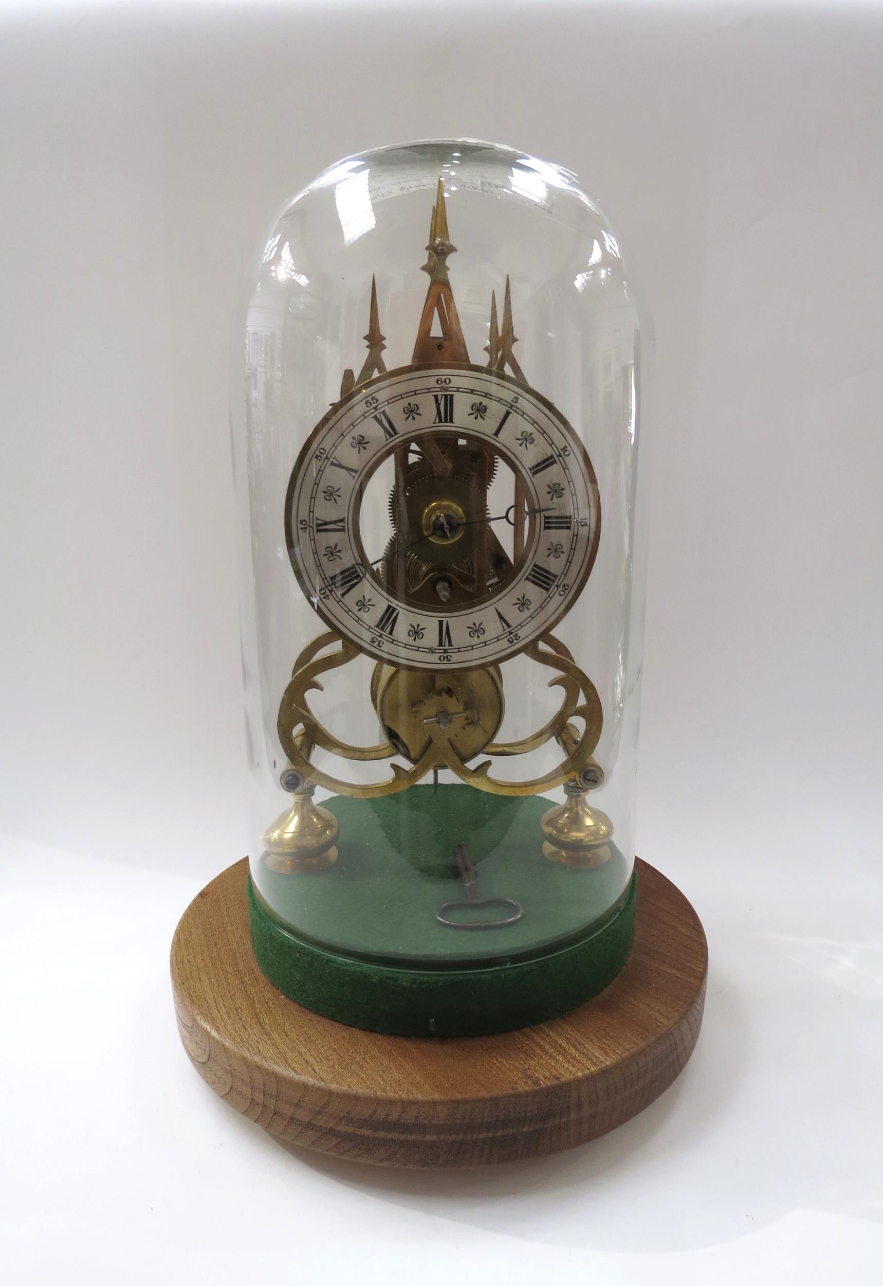 A 20th Century single fusee skeleton timepiece of Gothic design under glass dome. Roman silvered