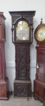 An 18th Century heavily carved oak longcase clock with silvered Roman chapter ring, date and seconds