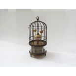 An automation bird cage clock encasing two birds above a spherical Arabic 12 hour dial, visible