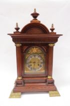 An early 20th Century oak bracket clock of architectural form. Silvered Roman chapter ring on